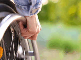 Hand holding a wheelchair.